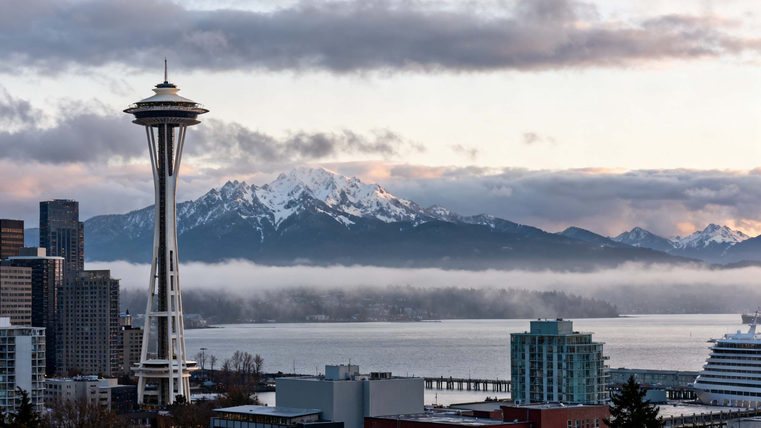 Seattle’s waterfront with the iconic Space Needle and rainy clouds over Puget Sound and mountain ranges