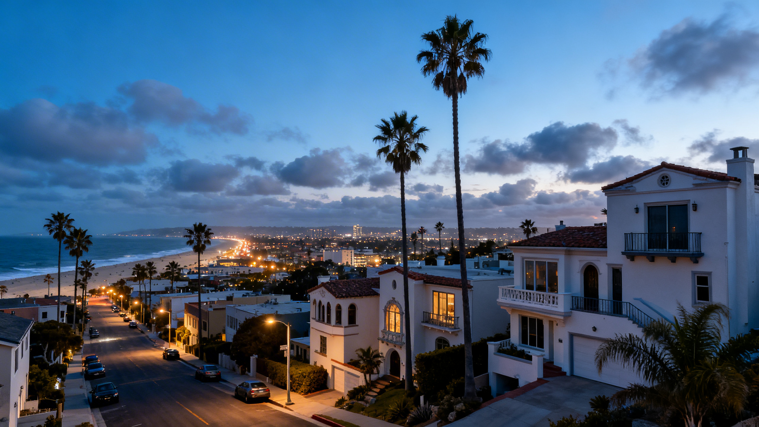 Coastal San Diego cityscape with beachside homes and palm trees lining streets under a partly cloudy sky.