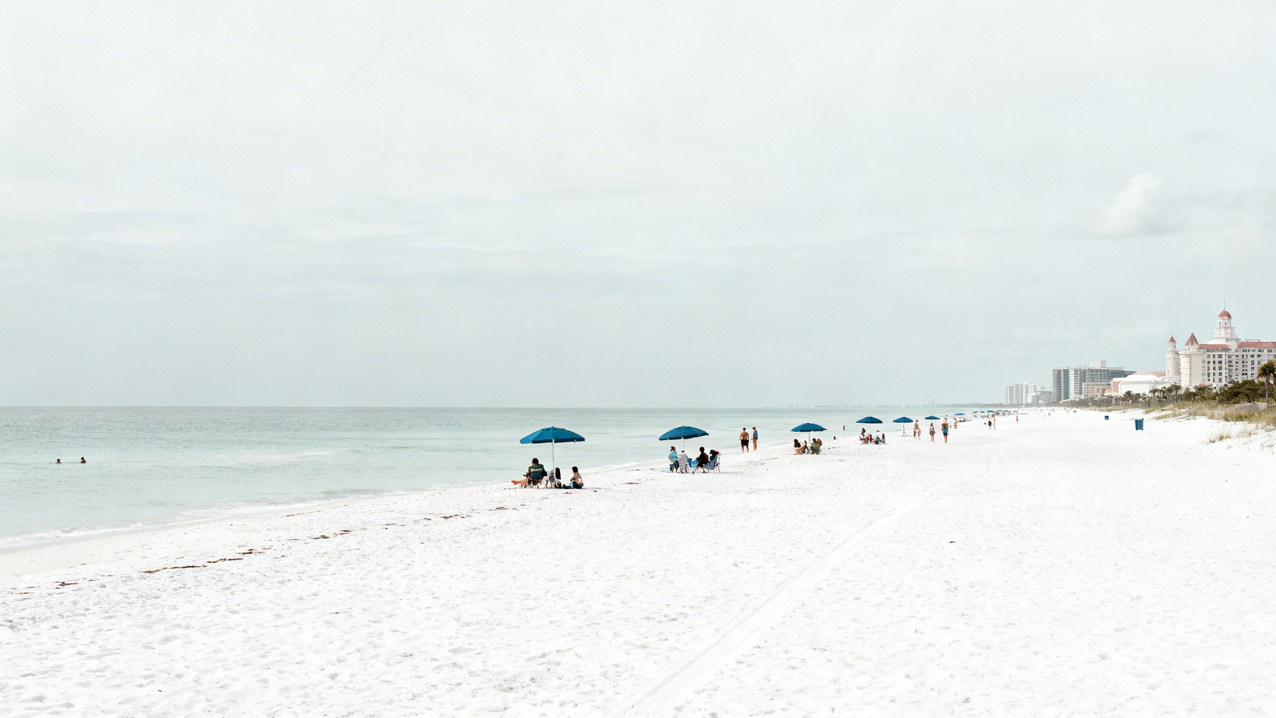 Wide white sand beaches and calm Gulf waters at Gulf Shores with families enjoying sunny weather and beach umbrellas.