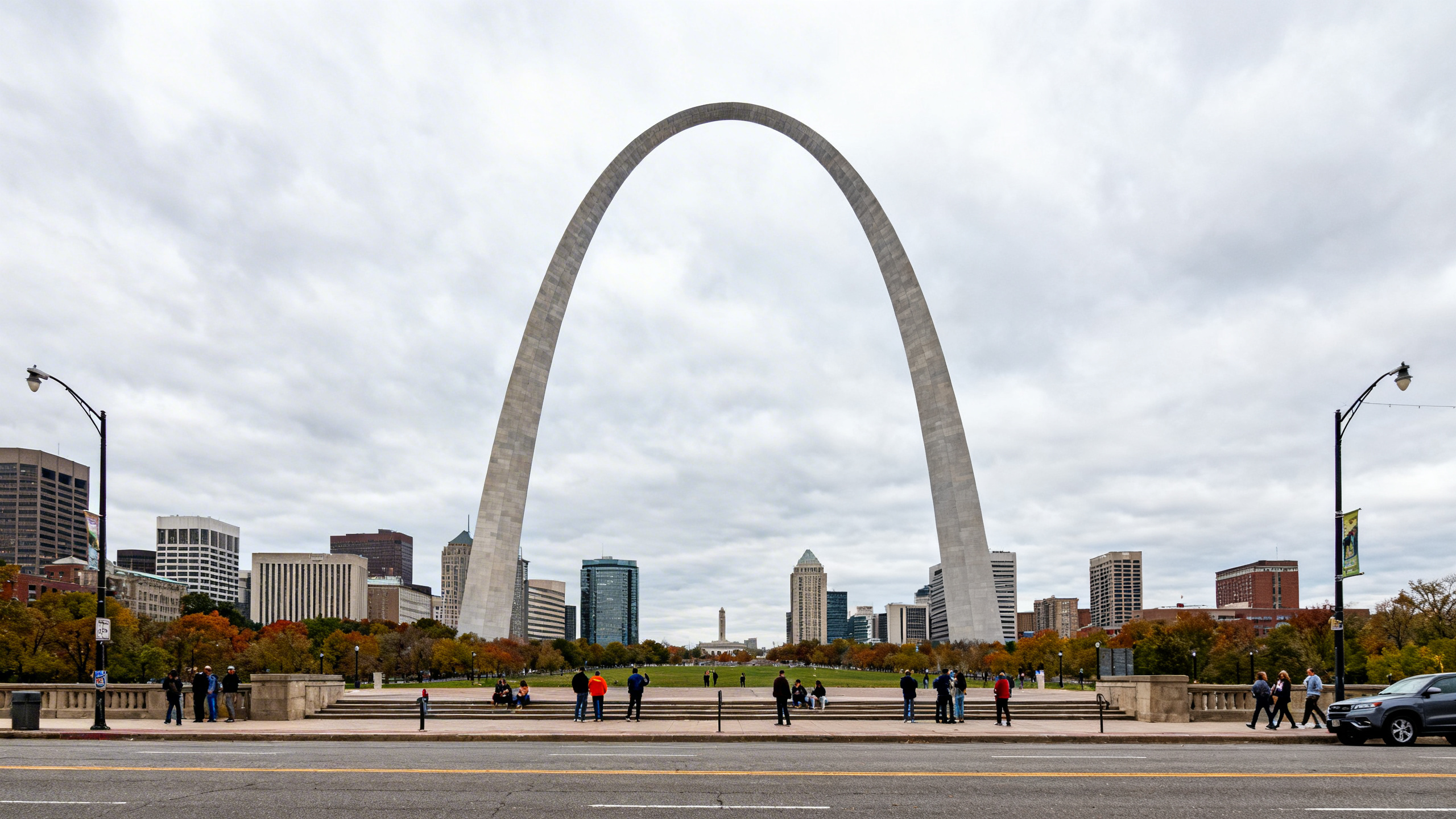 View of the iconic Gateway Arch against a cloudy sky, set amid the cityscape of St. Louis