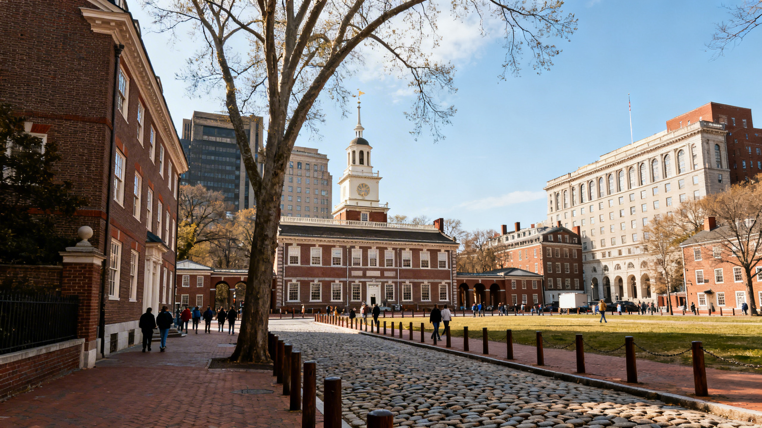 Street view of historic Philadelphia buildings and cobblestone sidewalks near Independence Hall on a sunny day