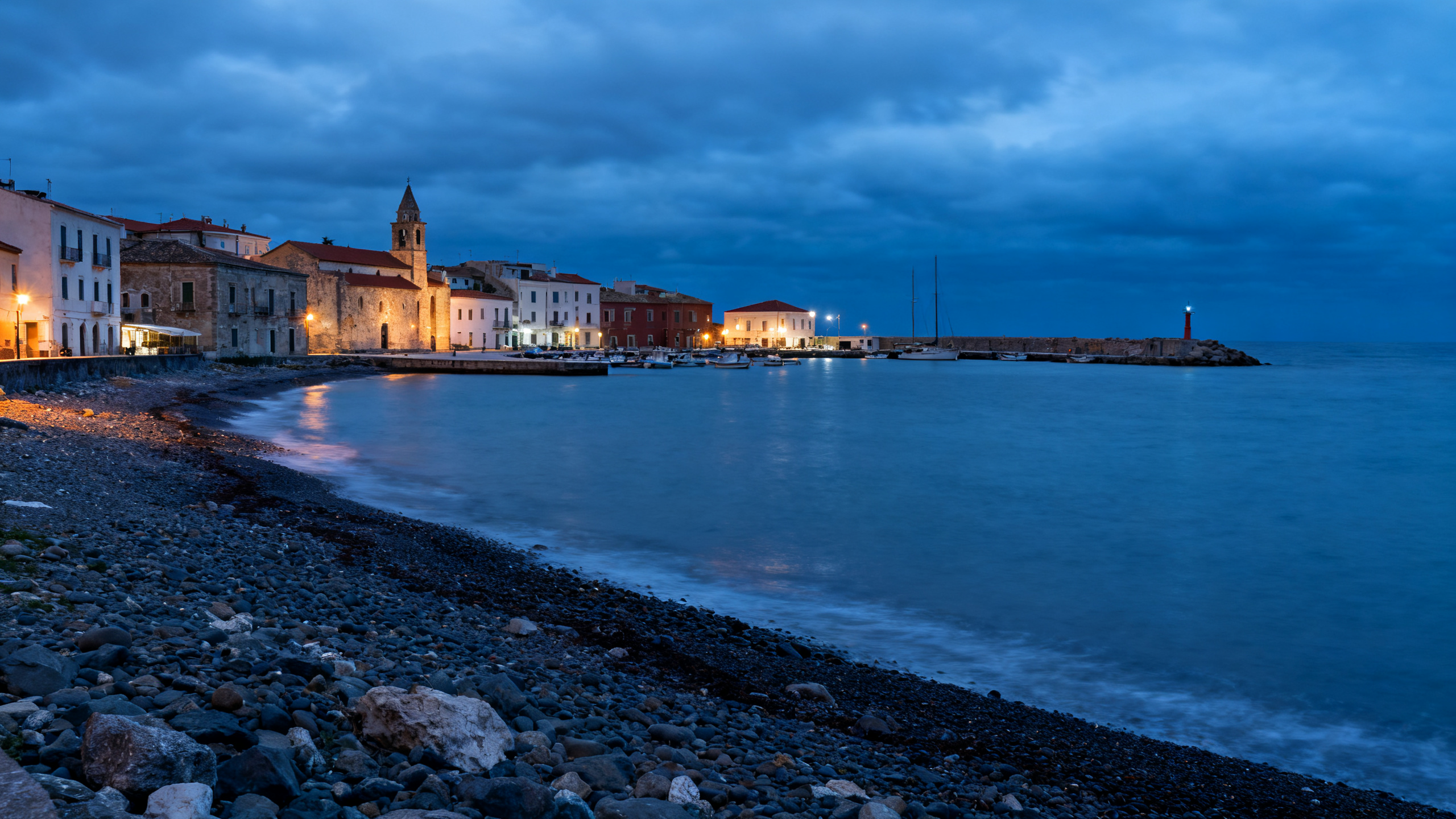 Lake Superior shoreline with rocky beaches stretching alongside a small city harbor under an overcast sky
