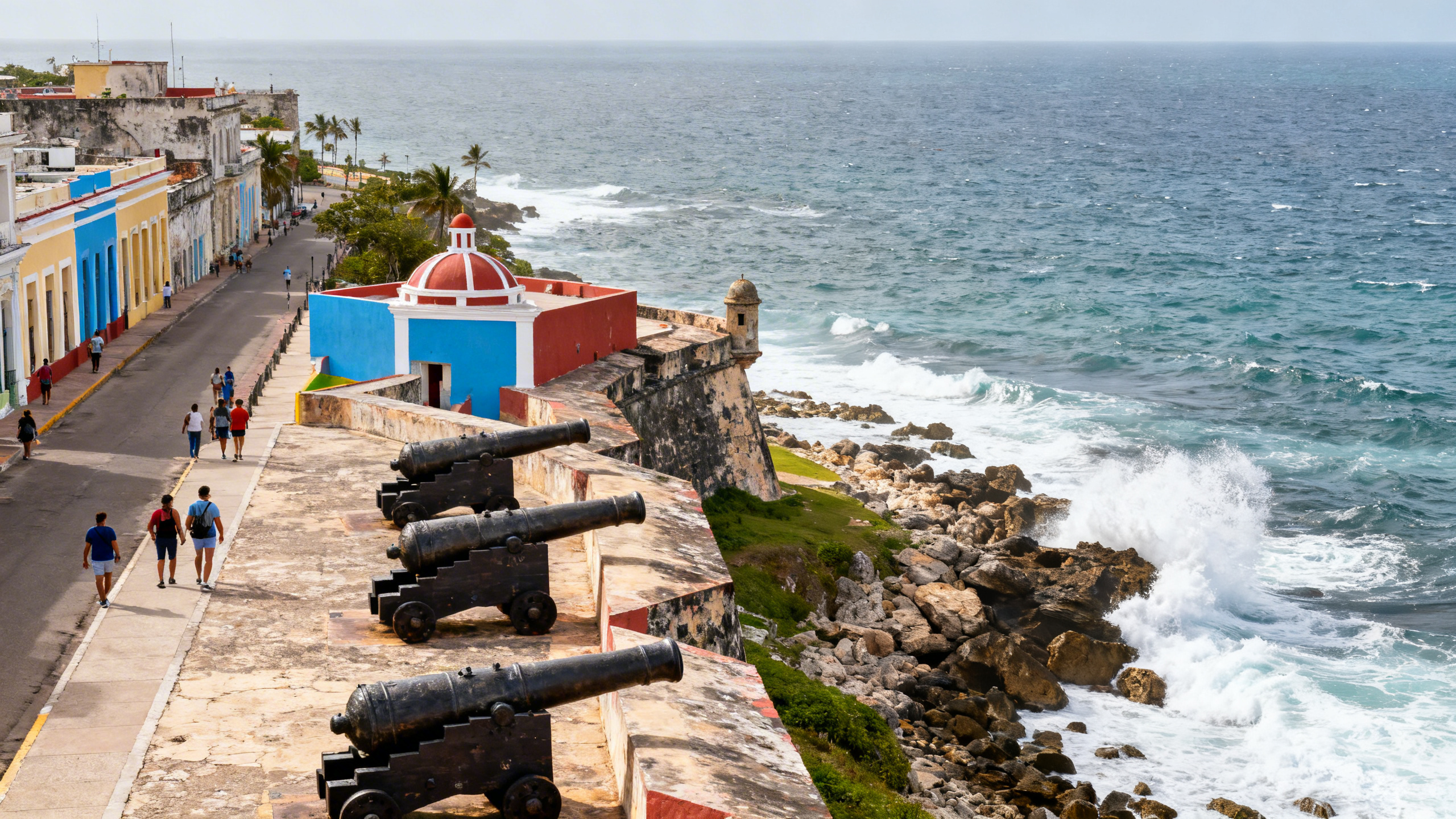 The colorful walls and cannons of El Morro fortress overlooking the Atlantic Ocean with waves crashing on rocky shores