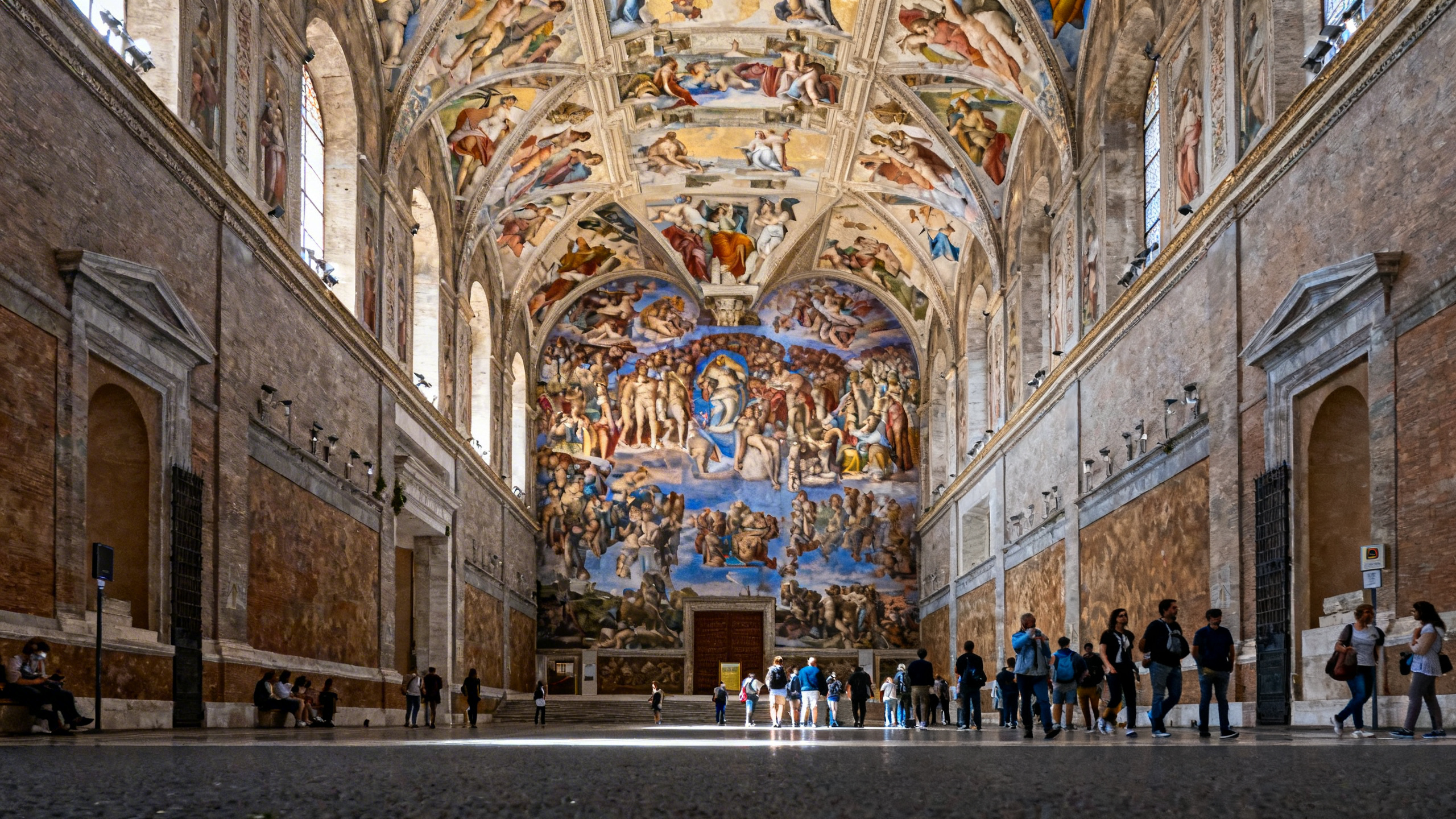 The ornate ceiling of the Sistine Chapel covered in Michelangelo’s frescoes, viewed from inside the Vatican Museums