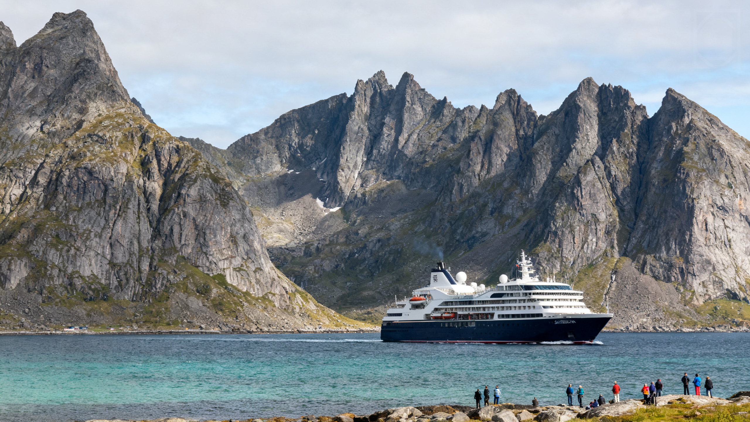 An elegant, smaller Seabourn cruise ship sailing past jagged coastal cliffs and crystal-clear waters in a remote, rugged wilderness setting.