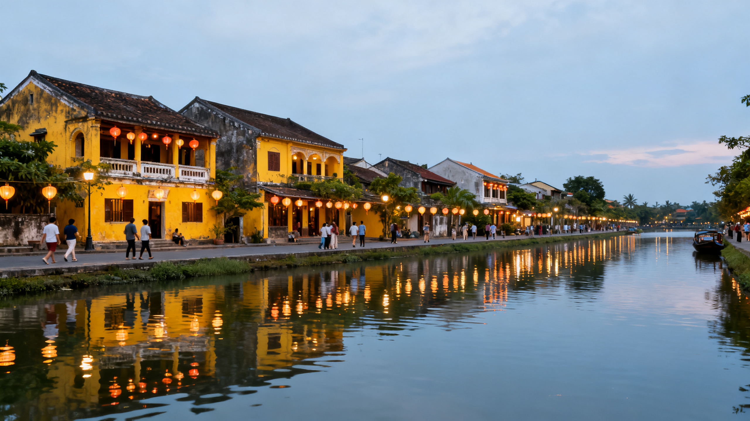 Ancient yellow-painted buildings and lanterns lining the river in Hoi An, with tourists strolling at dusk as lights reflect on the water