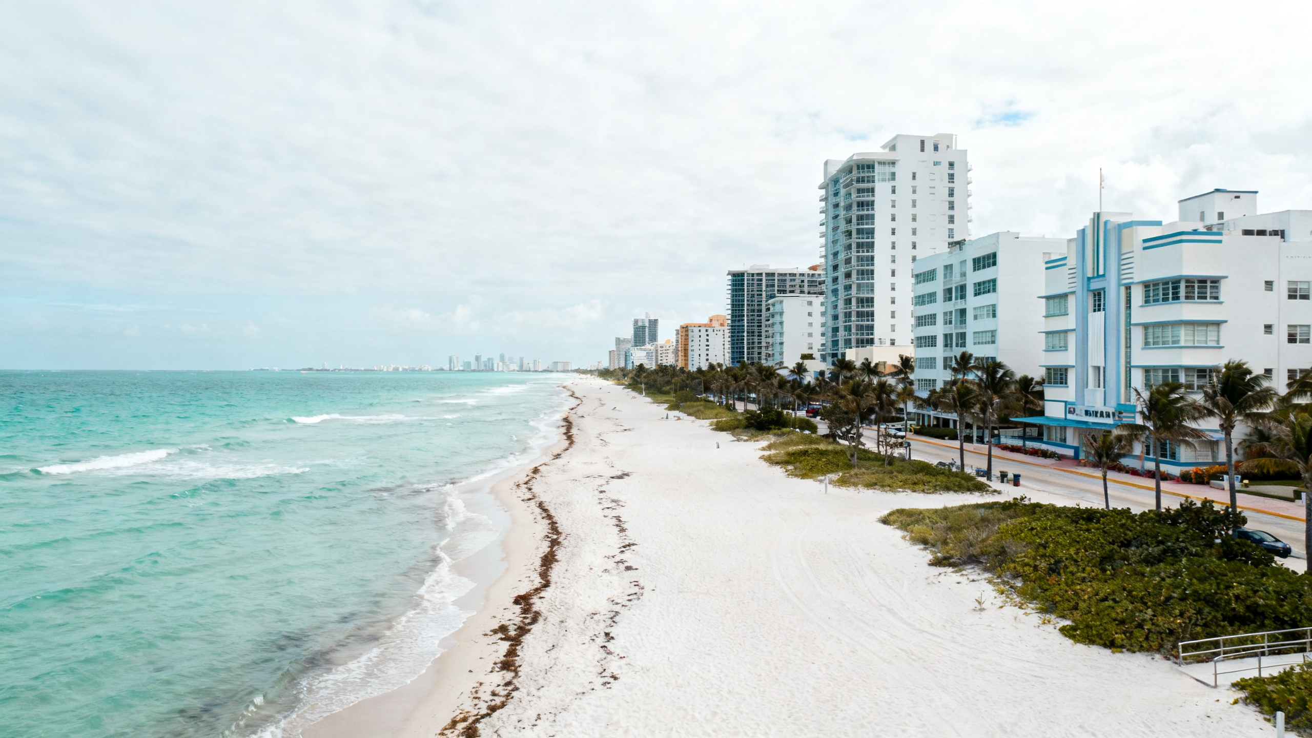 Miami Beach with aqua waters, white sandy shores, and Art Deco buildings under a sunny sky