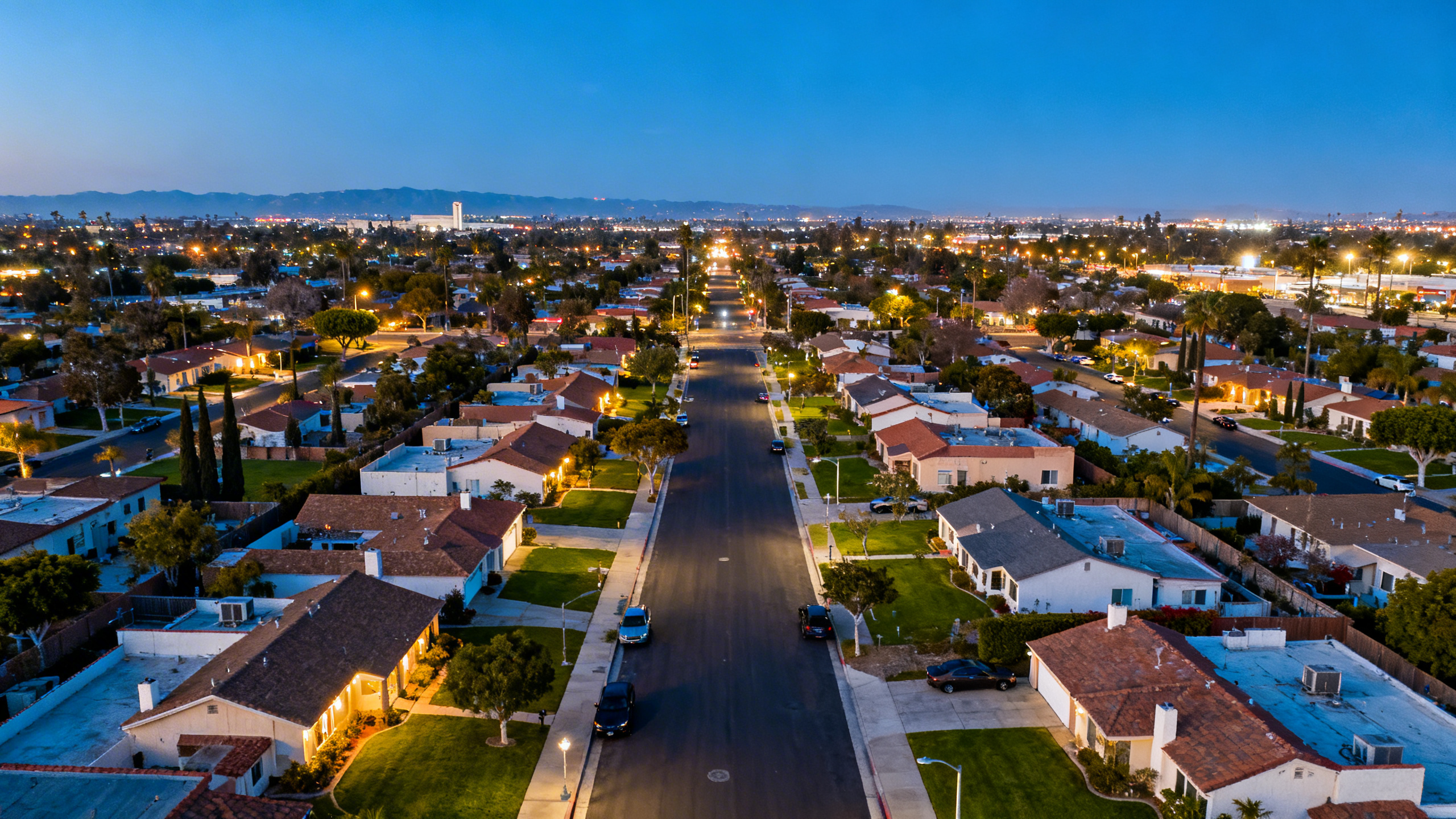 Broad streets lined with mid-century architecture and green spaces in residential Cerritos, California under a blue sky