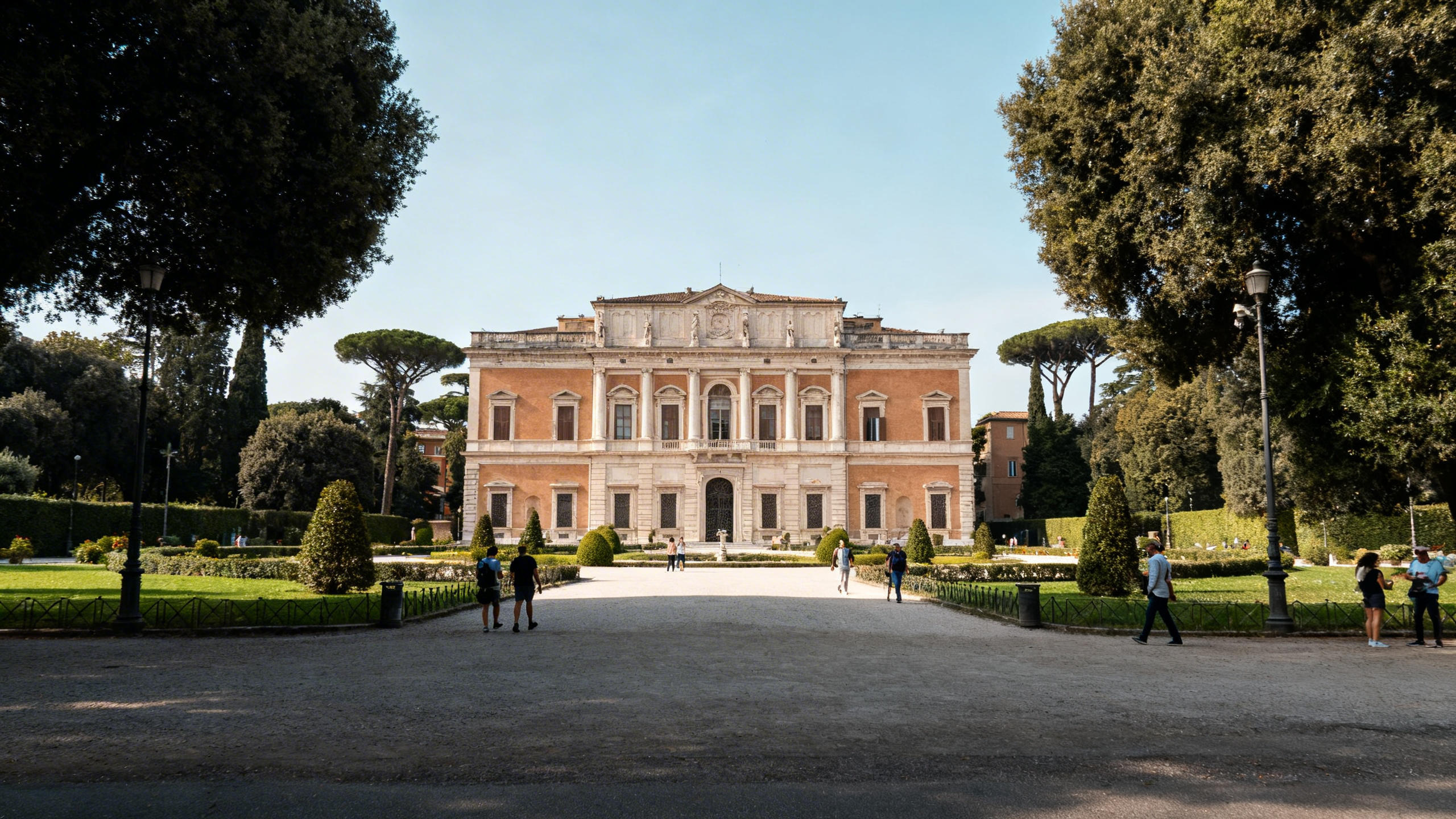 The elegant exterior of Villa Borghese with manicured gardens and a stately façade in the background